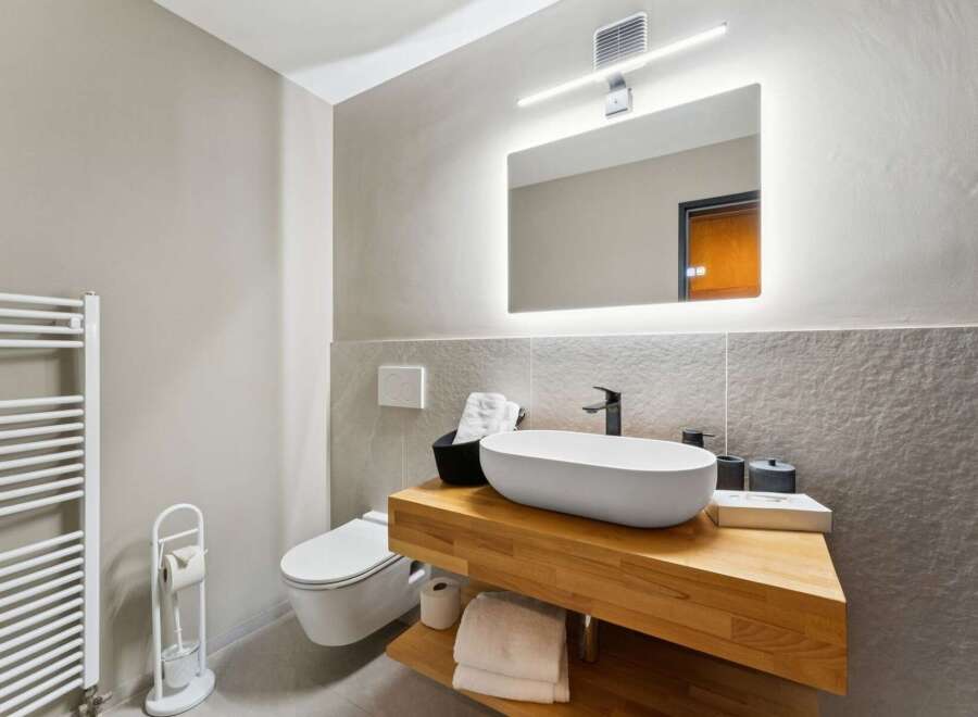 Experience modern comfort in this beautifully appointed bathroom, featuring a sleek floating vanity with a vessel sink and ample storage.