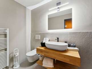 Experience modern comfort in this beautifully appointed bathroom, featuring a sleek floating vanity with a vessel sink and ample storage.