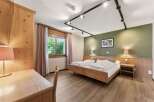 Experience rustic charm in this inviting hotel room, featuring a comfortable wooden bed and a functional desk area.