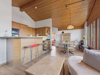 Experience modern living in this open-concept space featuring a sleek kitchen with ample cabinetry and a breakfast bar, perfect for casual dining.