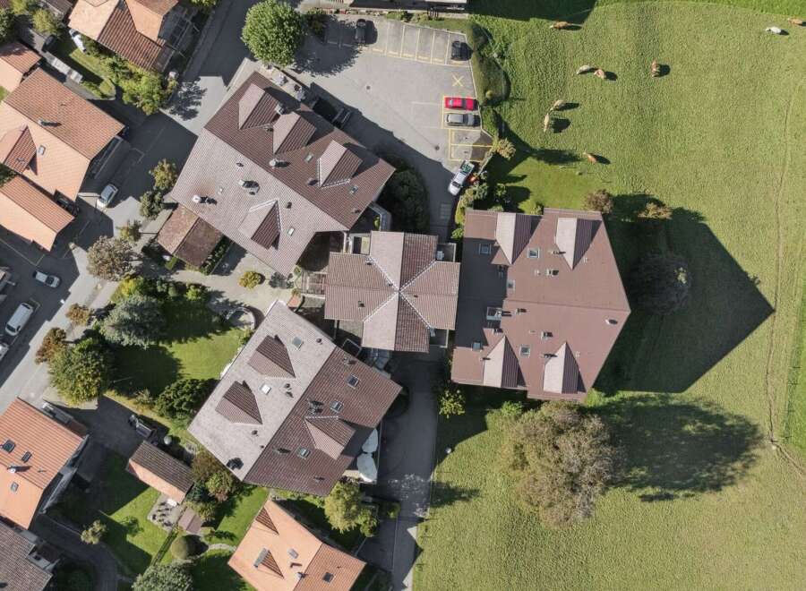 Discover this stunning aerial view of a residential area featuring modern homes with distinctive brown tile roofs.