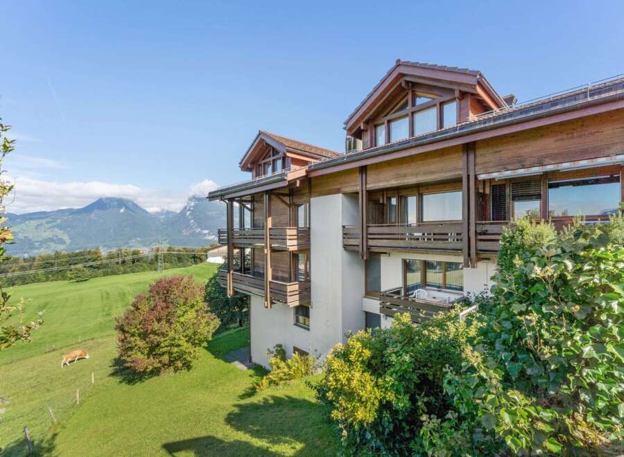 Experience breathtaking mountain views from this stunning property, featuring a modern wooden exterior and multiple balconies perfect for enjoying the scenery.