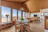 Experience breathtaking mountain views from this charming dining area, featuring a round table with four chairs and a large window overlooking the scenic landscape.