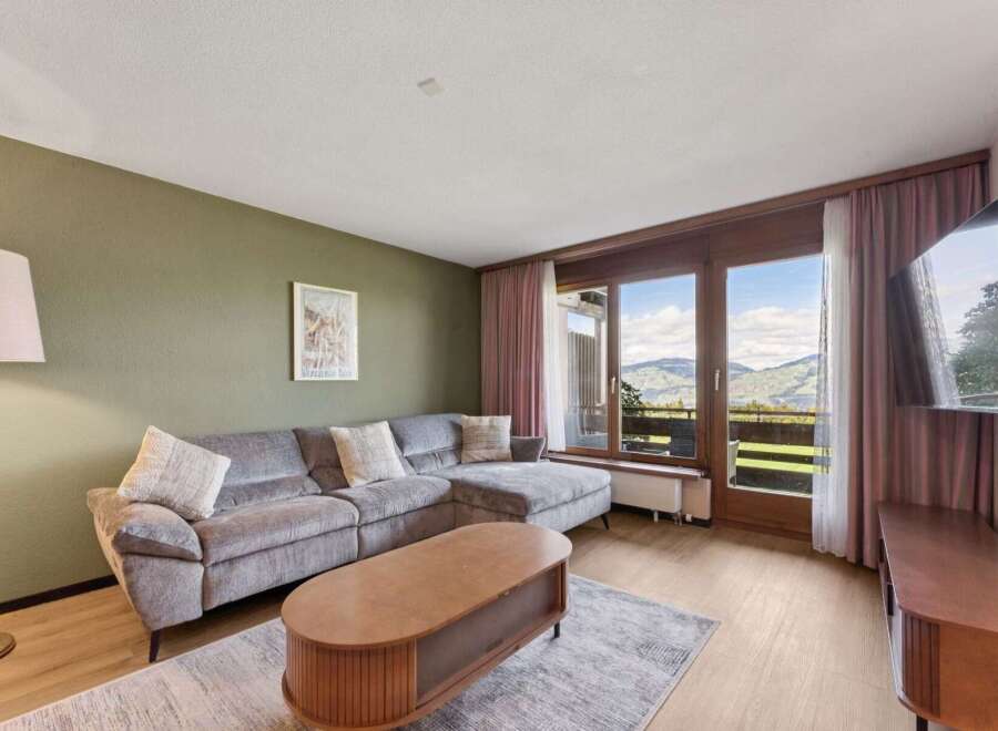 Experience breathtaking mountain views from this stunning living room, featuring a plush sectional sofa perfect for relaxation.