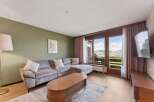 Experience breathtaking mountain views from this stunning living room, featuring a plush sectional sofa perfect for relaxation.