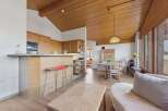 Experience modern living in this open-concept space featuring a sleek kitchen with ample cabinetry and a breakfast bar, perfect for casual dining.