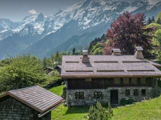 Nestled amidst lush greenery with a majestic mountain backdrop, this charming stone and wood chalet offers a serene retreat.