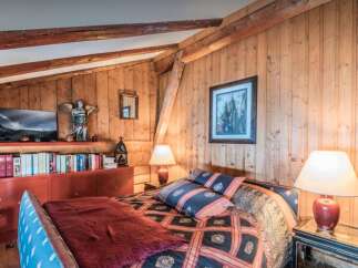 This charming bedroom features a cozy bed adorned with patterned pillows and a plush throw, perfect for relaxation.
