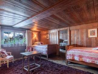 Experience rustic charm in this cozy bedroom featuring two inviting beds with patterned comforters.
