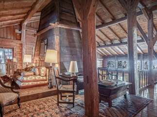 Experience rustic charm in this spacious loft featuring exposed wooden beams and a grand stone fireplace.