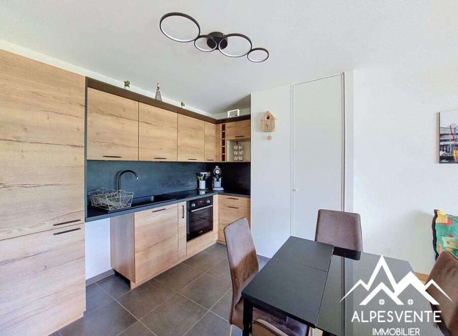 Discover this modern kitchen featuring sleek wooden cabinetry and a dark, contrasting backsplash.