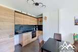 Discover this modern kitchen featuring sleek wooden cabinetry and a dark, contrasting backsplash.