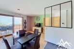 Experience modern living in this spacious dining and living area, featuring a sleek black dining table set for intimate gatherings.