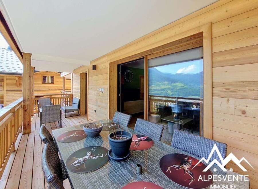Enjoy breathtaking mountain views from this charming wooden chalet's spacious balcony, perfect for al fresco dining.