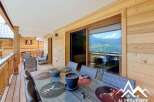 Enjoy breathtaking mountain views from this charming wooden chalet's spacious balcony, perfect for al fresco dining.