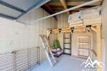 Discover this versatile space, perfect for storage or a workshop, featuring ample shelving and a sturdy ladder for easy access.