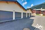 Discover this property featuring a row of modern garages with sleek, dark gray doors, perfect for secure vehicle storage.