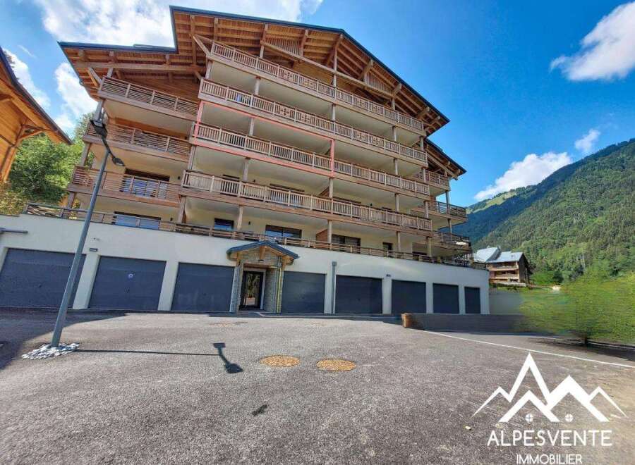 Discover this stunning multi-story apartment building nestled in a picturesque mountain landscape.