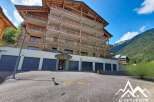 Discover this stunning multi-story apartment building nestled in a picturesque mountain landscape.