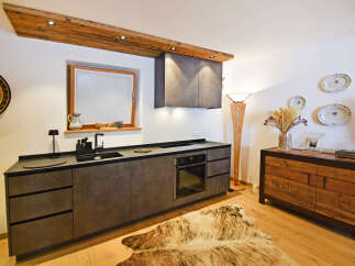 Experience rustic charm in this modern kitchen featuring sleek, dark cabinetry and a built-in oven.