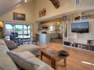 Experience comfortable living in this spacious open-concept home, featuring a large sectional sofa and a rustic coffee table perfect for gatherings.
