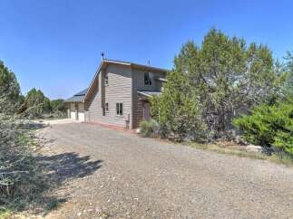 Discover this charming home featuring a spacious gravel driveway leading to a two-car garage.