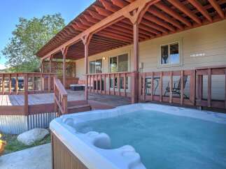 Relax and unwind in this charming property featuring a spacious wooden deck and a luxurious hot tub, perfect for enjoying the outdoors.
