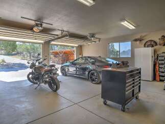 This spacious garage offers ample storage and parking for your vehicles, including a sleek sports car and a motorcycle.