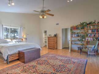 This spacious bedroom offers a cozy retreat with a large bed, ample storage, and a beautiful built-in bookshelf filled with decorative items and books.