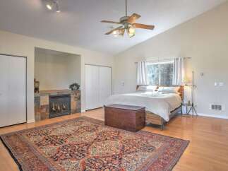 Experience cozy comfort in this inviting bedroom, featuring a charming fireplace with a slate tile surround and a spacious layout.