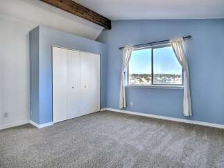 Discover this charming bedroom featuring a spacious closet and a large window offering scenic views.