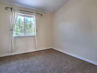 This unfurnished bedroom offers a serene retreat with its neutral-toned walls and plush carpeting.