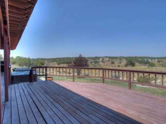 Enjoy breathtaking panoramic views from this expansive wooden deck, perfect for entertaining or relaxing.