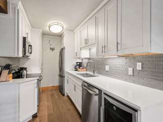 This modern kitchen boasts sleek white cabinetry and a stunning grey subway tile backsplash.