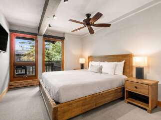 Experience ultimate comfort in this inviting bedroom, featuring a luxurious king-size bed with plush white linens and a decorative lumbar pillow.