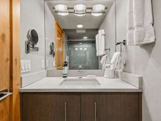 Experience modern luxury in this beautifully appointed bathroom, featuring a sleek vanity with a quartz countertop and a spacious undermount sink.