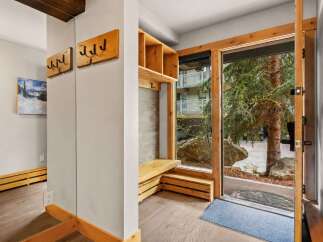 Step into this charming entryway featuring a rustic wooden bench with built-in storage, perfect for stowing away outdoor gear.