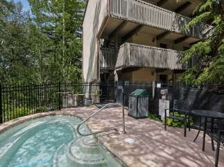 Enjoy a relaxing soak in this inviting hot tub, surrounded by lush greenery and the serene ambiance of the mountains.