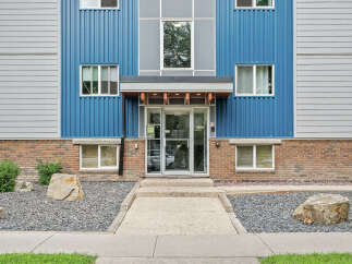 Discover modern living in this apartment building featuring a striking facade with blue and gray corrugated metal siding.