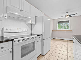 Discover this charming kitchen featuring crisp white cabinetry and sleek granite countertops.