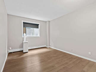 This bright and airy room features a large window with a roller shade, providing ample natural light.