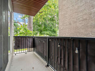 Enjoy your morning coffee or evening relaxation on this charming balcony, complete with a privacy screen and decorative string lights.