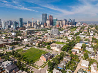 Experience urban living at its finest with this stunning aerial view of a vibrant city skyline, featuring modern high-rises and a prominent observation tower.