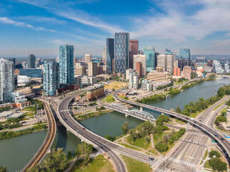 Experience urban living at its finest with this stunning aerial view of a modern cityscape featuring sleek skyscrapers and a vibrant riverfront.