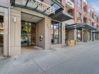 Discover modern urban living at The Mercer, a stylish building featuring a prominent entrance with clear signage and address '34 56'.