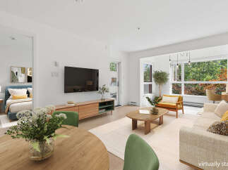 Experience modern living in this beautifully staged open-concept space, featuring a cozy living area with a large TV and entertainment unit, flowing into a dining area perfect for intimate meals.