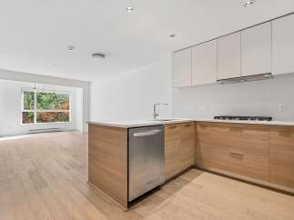 Experience modern living in this stunning kitchen featuring sleek white cabinetry and warm wood accents.