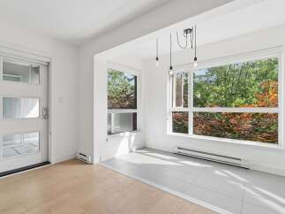 Bright and airy living space featuring a modern aesthetic with large windows that flood the room with natural light.