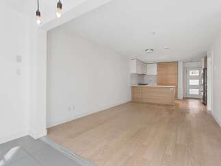 Experience modern living in this bright and airy open-concept space featuring a sleek kitchen with ample cabinetry and a stylish island.