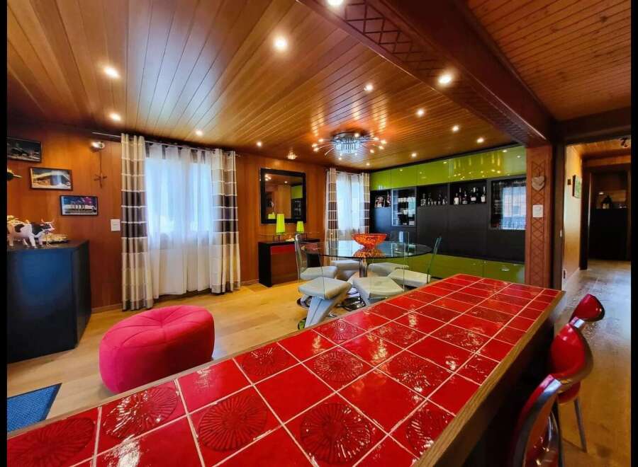 Experience modern living in this stunning home featuring a vibrant red tiled breakfast bar, perfect for casual dining and entertaining.